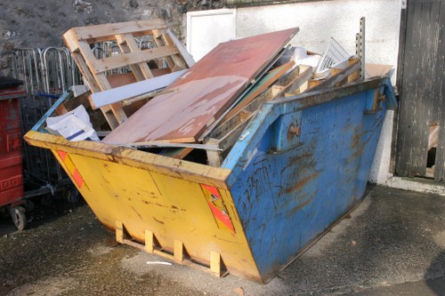 Local rubbish removal crew carrying a mattress from a property